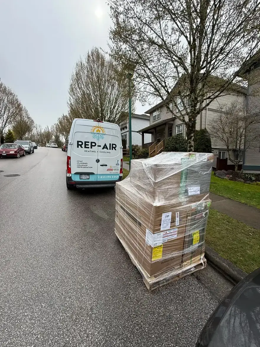 Rep-Air van beside a pallet of equipment on a residential street