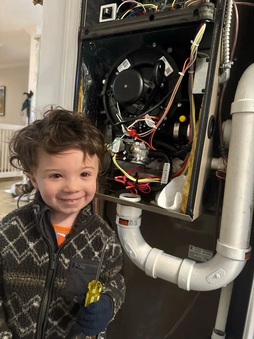 Child standing beside an open furnace