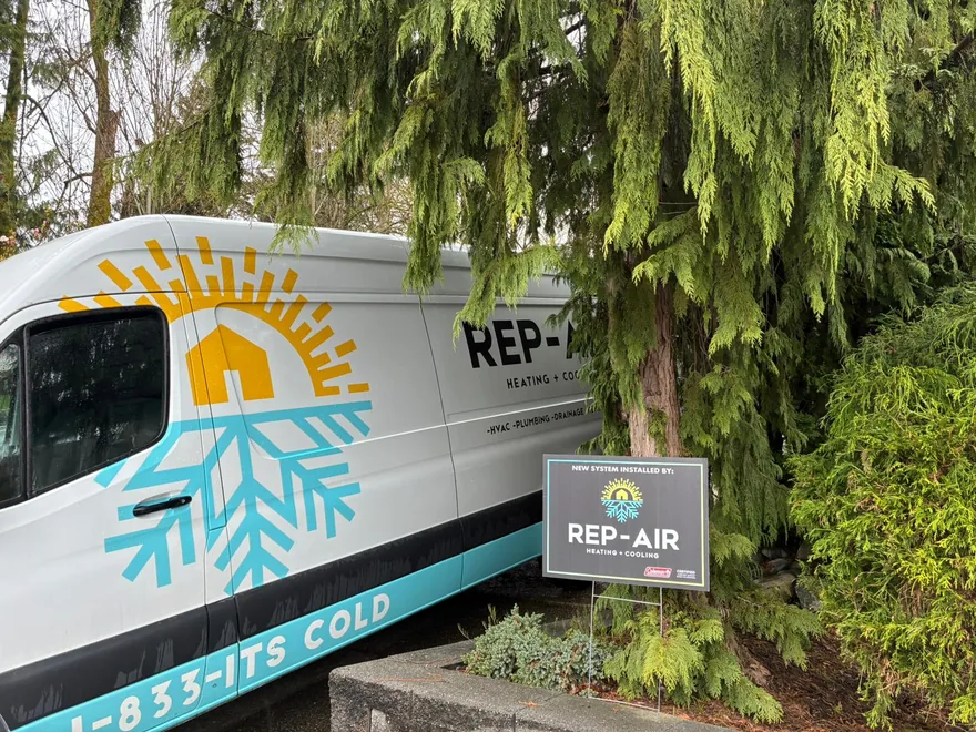 Rep-Air van and yard sign beside a hedge