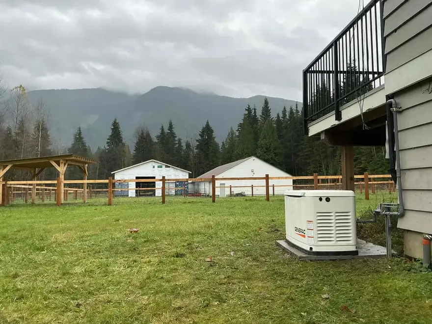 Standby generator on a pad beside a rural home