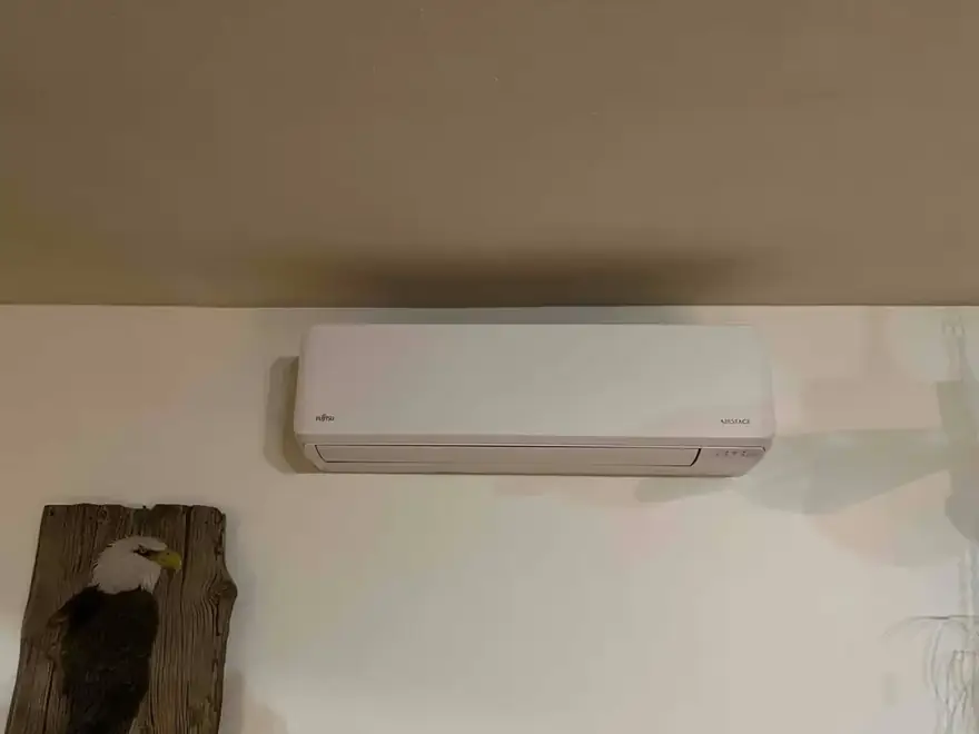 Ductless mini-split head mounted high on a white wall