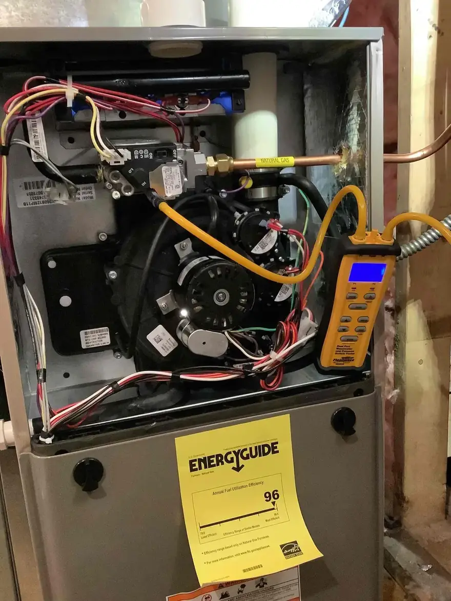 Open furnace burner compartment with a test meter attached