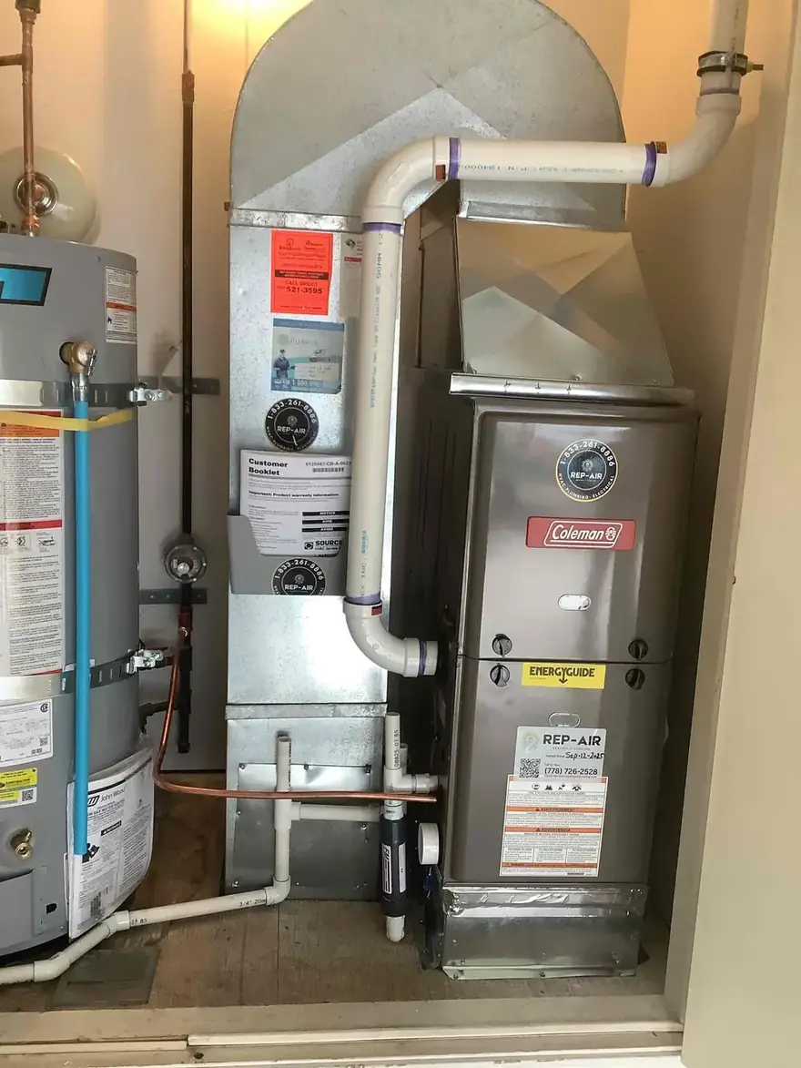 Coleman gas furnace beside a gas water heater in a closet