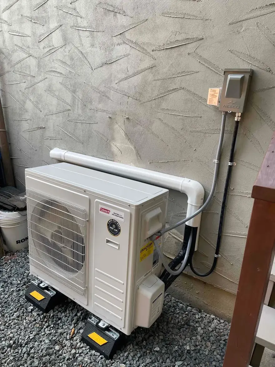 Heat pump outdoor unit on risers with a line set cover