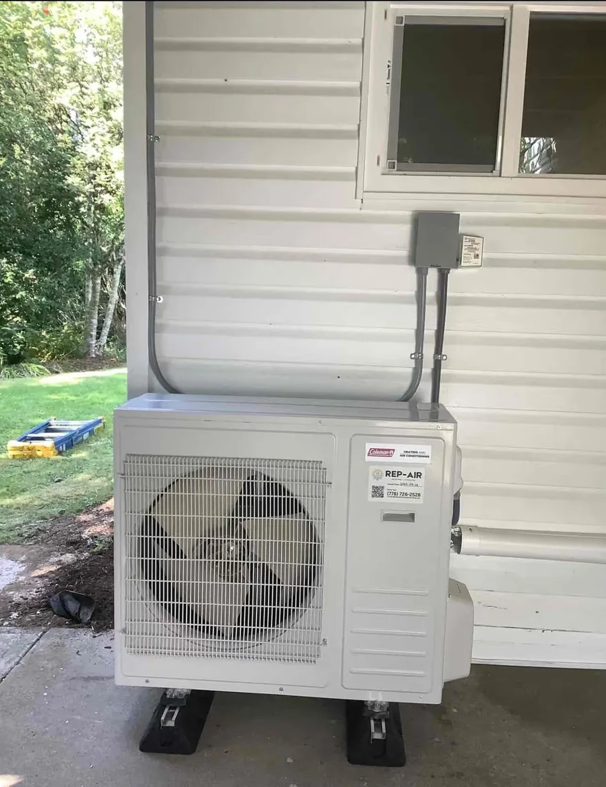 Coleman heat pump outdoor unit beside a white-sided house