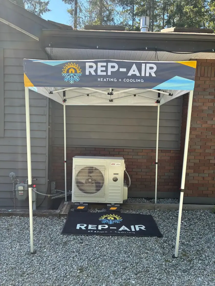 Heat pump outdoor unit under a Rep-Air branded canopy