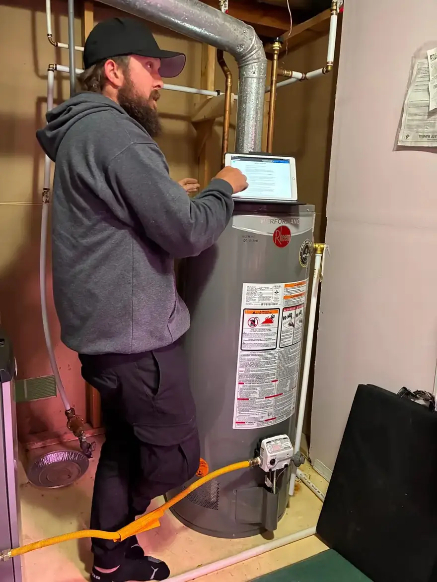 Technician checking a gas water heater with a tablet