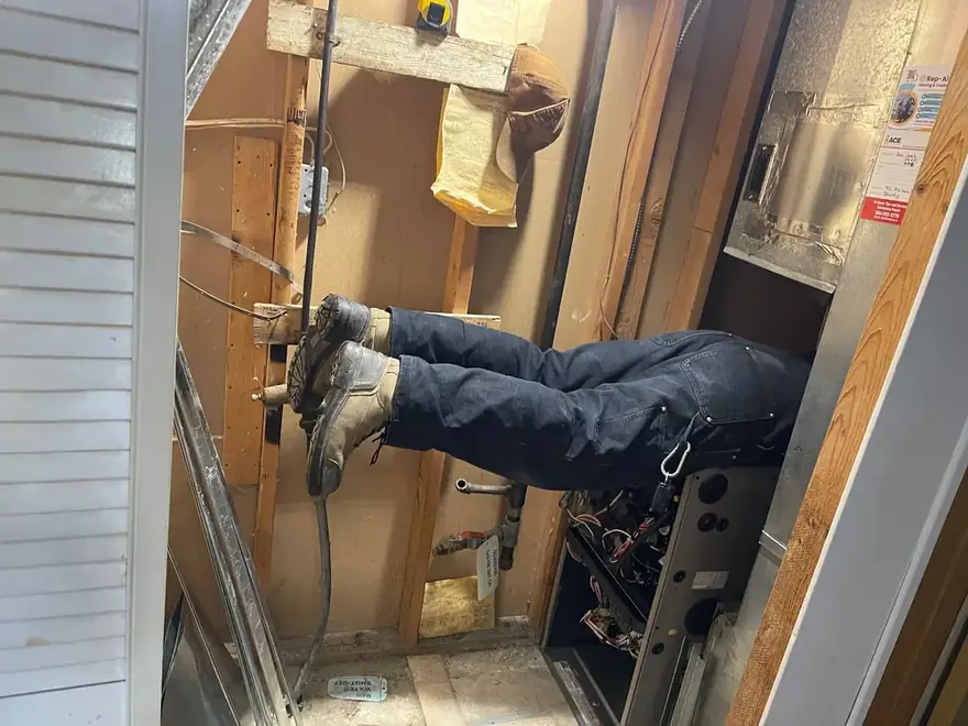 Technician reaching into a tight wall cavity during an install