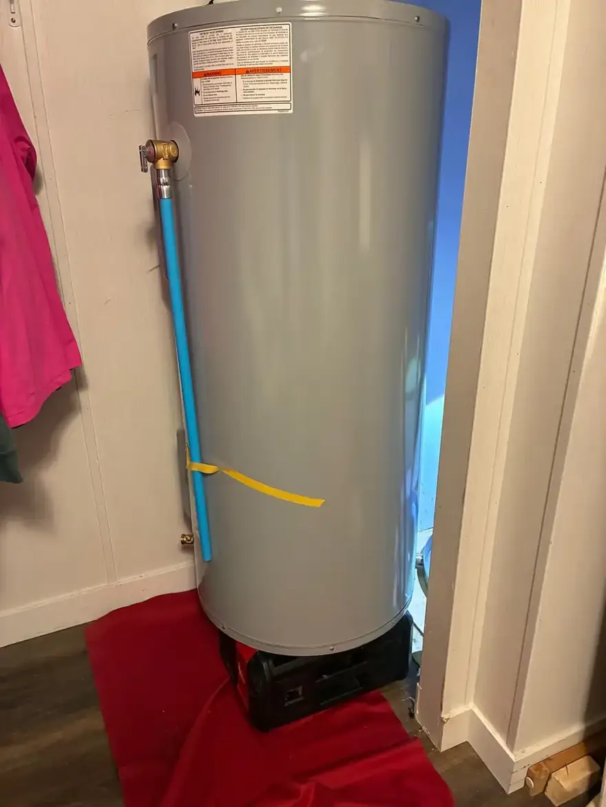 Electric water heater on a drain pan in a closet