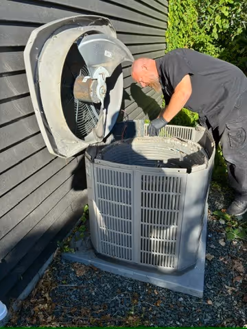 Rep-Air technician cleaning the inside of a central air conditioner